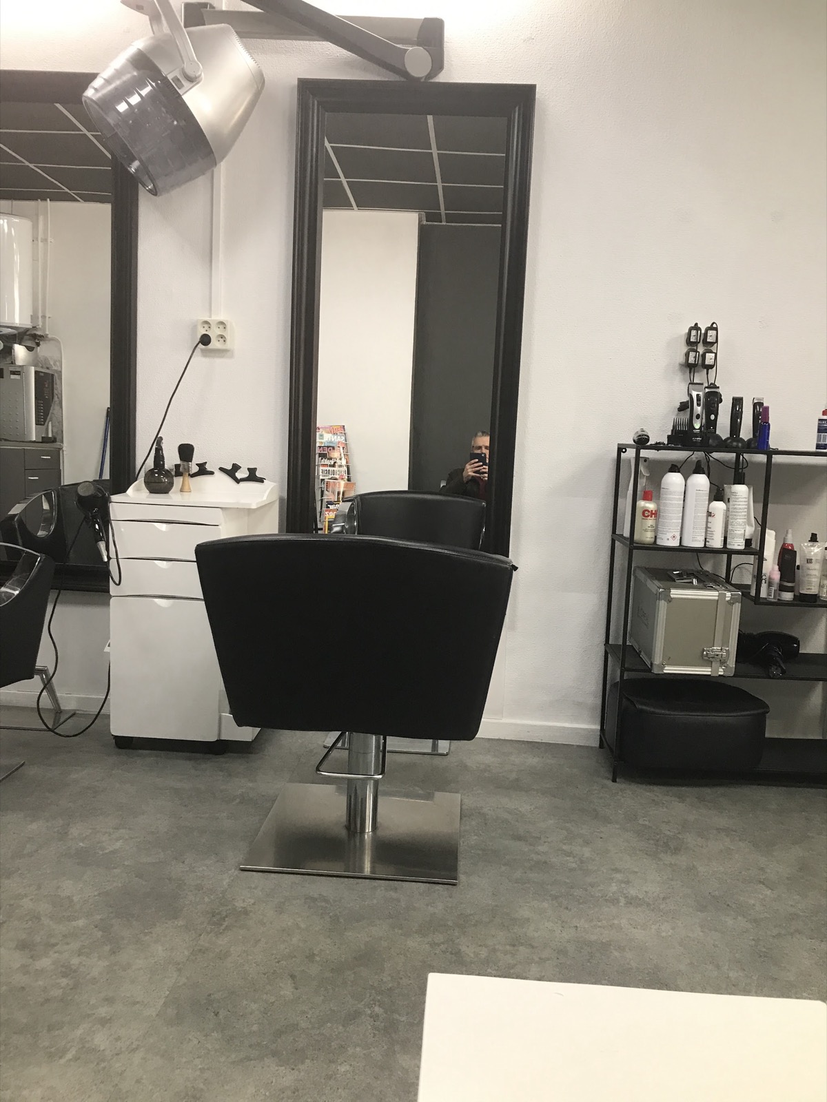 Een knipstoel en spiegel in de salon van Fancy Hair